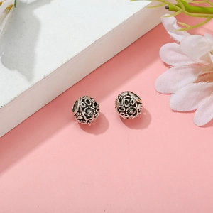 Macro view of vintage silver hollow round charms with heart and pet paw patterns for DIY