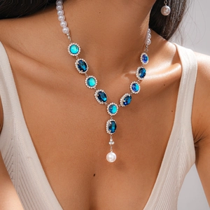 Macro shot of vintage pearl necklace with blue crystal pendant and sparkling rhinestones