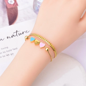 Double-layered gold chain bracelet with blue, pink, and gold heart-shaped pendants