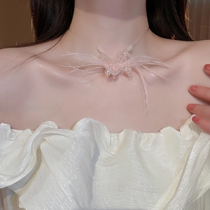 Close-up of elegant pink feather and bead butterfly necklace worn on the neck