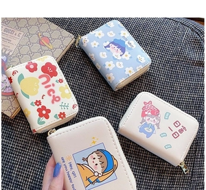 Flat lay of colorful cartoon mini card holders with zipper closures and various patterns