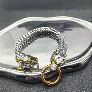Detailed view of Viking wolf head charms on Franco Link bracelet with gold accents