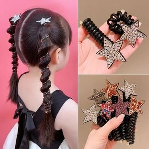Gros plan d'élastiques spirales noirs avec des étoiles en strass colorés pour filles