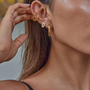 Gros plan de boucles d'oreilles et d'un ear cuff en acier inoxydable doré 18 carats