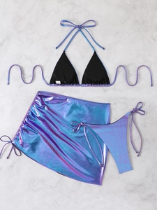 Detailed flat lay of shimmer purple three-piece bikini set on marble surface