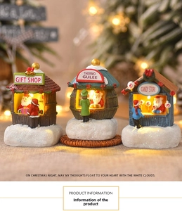 Detailed view of glowing resin Christmas village houses featuring a Santa Claus gift shop