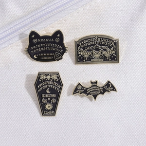 Set of 4 black enamel pins featuring bat, cat and Ouija board designs for Halloween