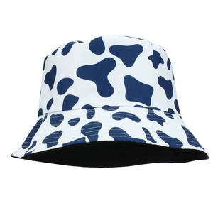 Dettaglio ravvicinato della stampa mucca su cappello a secchiello reversibile con fodera nera