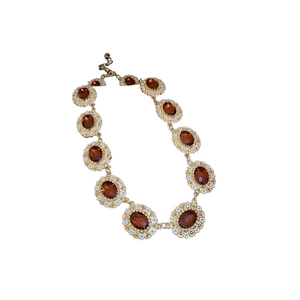 Vintage gold necklace set with oval amber gemstones and white enamel flower details