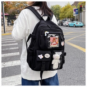 Detail of black multi-pocket backpack with cute pins and clear PVC windows worn on back