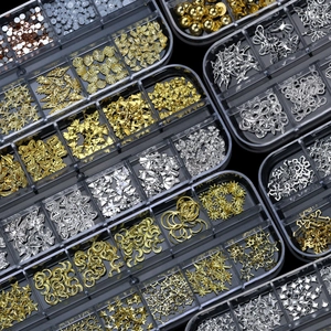 Vista dettagliata di borchie in metallo oro e argento per nail art in una scatola trasparente