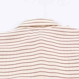 Detalle de camisa de rayas beige claro que muestra el cuello posterior y costura del hombro