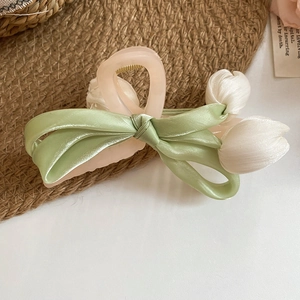 Detail of tulip fabric flower hair claw with light green satin ribbon bow and pink clip