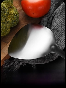 Close-up of brushed stainless steel ice clip on wooden board in kitchen setting