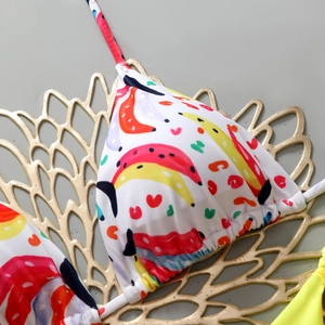 Close-up of bikini top featuring banana and heart patterns with detailed halter neck ties