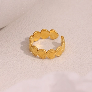 Detail of 18K gold plated heart embossed pattern on an open stainless steel ring