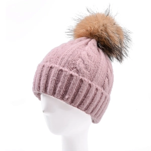 Berretto in maglia a trecce rosa con grande pompon in ecopelliccia su manichino