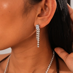 Close-up of elegant long silver tassel earrings with geometric zircon stone settings
