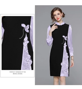 Dettaglio di elegante abito cheongsam nero con polsini viola e ricamo a farfalla 3D