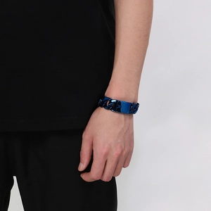 Detail view of 20mm blue metallic Cuban link bracelet worn on a male model wrist