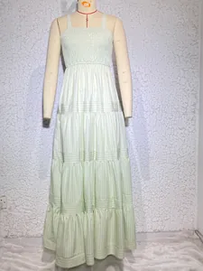 Detail of smocked bodice and thin straps on a light green striped tiered maxi dress