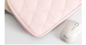 Close-up of pink quilted laptop sleeve with focus on smooth zipper and stitching