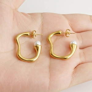 Irregular 18K gold-plated earrings with pearls shown in hand for scale and detail