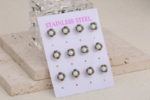 Set of 6 pairs vintage stainless steel floral stud earrings with pearl centers on display