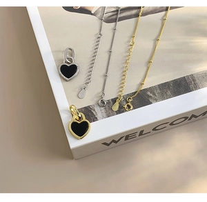 Detail shot of S925 sterling silver stamp on the delicate gold heart necklace chain
