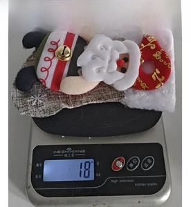 Detail showing Santa Claus Christmas stocking ornament weighing 18 grams on a scale