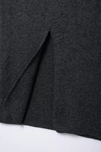 Detailed macro view of the dark grey knit fabric texture with a side slit design detail