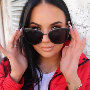 Close-up of trendy black cat eye sunglasses with dark lenses on a fashion model