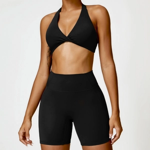 Two-piece black yoga set with twist front halter bra and high-waist biker shorts