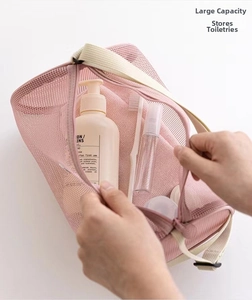 Pink mesh toiletry bag with large capacity for travel showing brushes and lotions