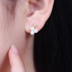Elegant gold earrings with white pearls and crystals in a grape cluster design on ear