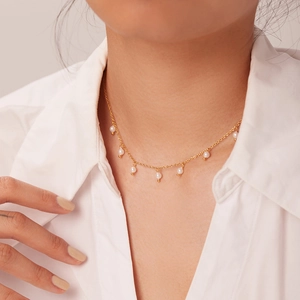 Detail of 18K gold stainless steel choker with delicate pearl fringe on a model