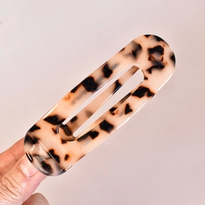Close-up of tortoise shell pattern acetate hair claw with minimalist hollow design