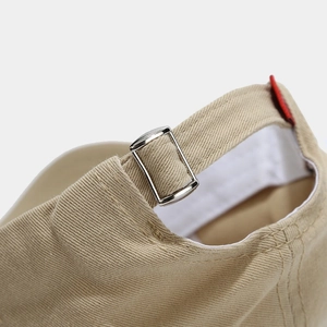 Detail of adjustable metal slider and cotton fabric texture on khaki baseball cap