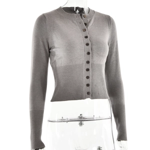 Detail of grey cropped knitted cardigan featuring round neck and fine ribbed cuffs