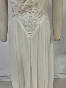 Detail of elegant white dress featuring 3D floral textures and intricate lace stitching