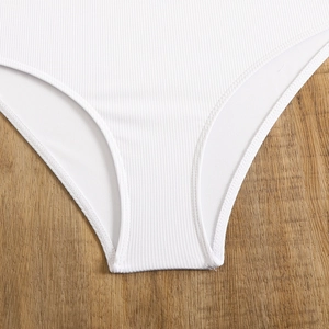 Close-up of white ribbed fabric texture and premium stitching on this high-waisted swimsuit