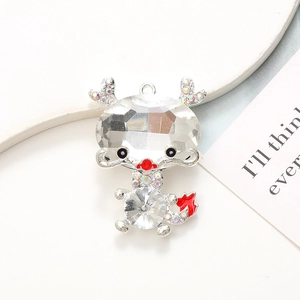 Detail of dragon pendant with clear faceted crystal head and red enamel tail accent