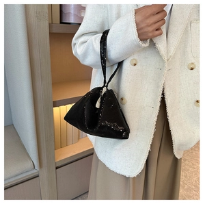 Vue détaillée d'un sac de soirée noir à paillettes avec une forme triangulaire unique
