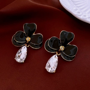 Détail macro de boucles d'oreilles vintage fleurs noires et cristal en goutte d'eau