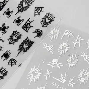 Macro detail of Halloween nail stickers with black spiders and heart spiderweb designs