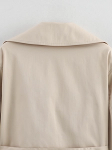Gros plan détaillé du col du trench-coat beige et texture du tissu tissé sur surface plane
