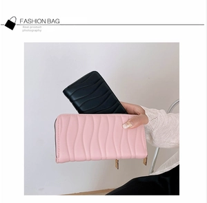 Close-up of black and pink long zip wallets featuring textured wave stitching pattern