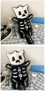 Detalle de bolso monstruo de peluche negro con patrones de gato esqueleto en fondo a cuadros