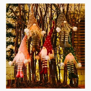 Set of five glowing Christmas gnomes with warm LED lights on a rustic winter branch