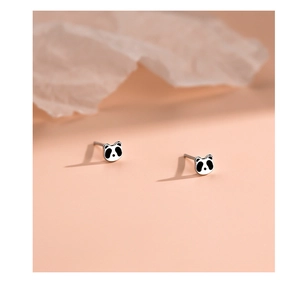 Makroaufnahme von niedlichen S999 Silber Panda Ohrsteckern auf einem weichen Hintergrund